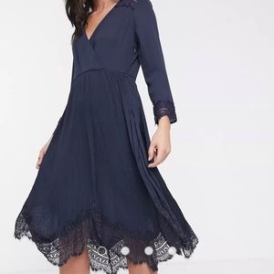 Elegant wrap dress with pleated skirt and lace hem
